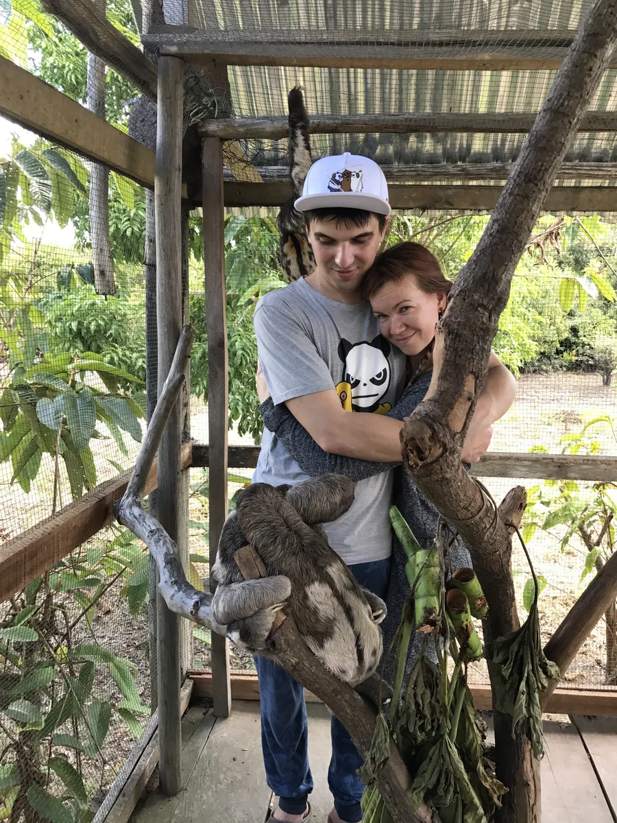 Visitors with a sloth at an animal rescue center near Iquitos